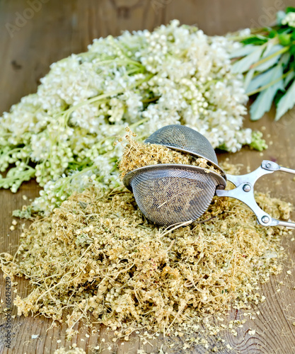 Herbal tea of meadowsweet in strainer on board
