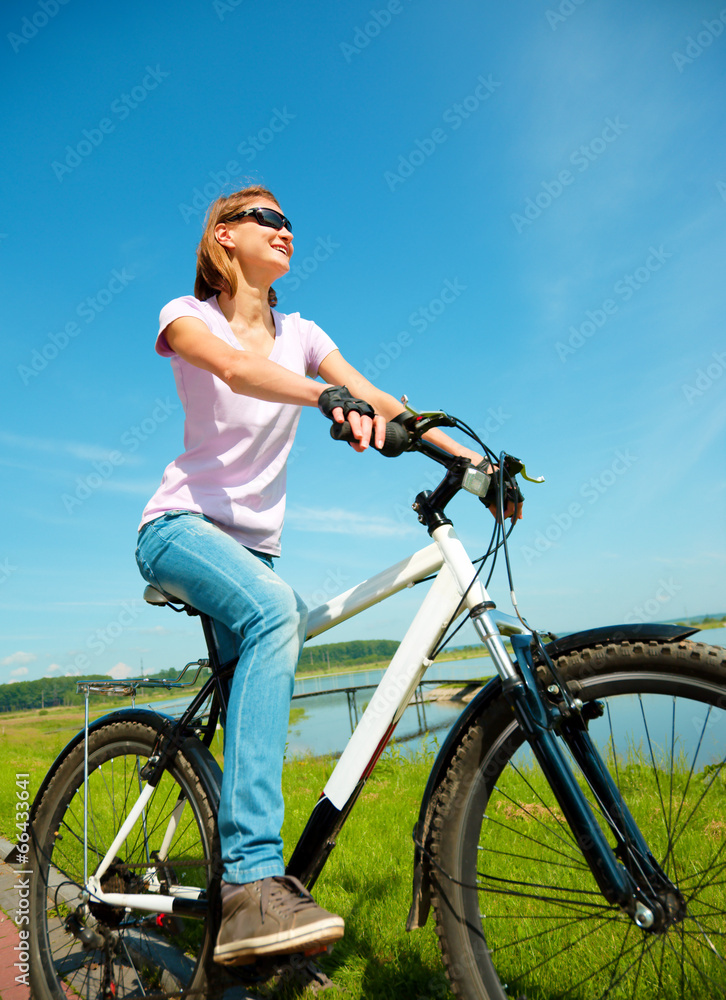 Young woman is sitting on her bicycle Young woman is sitting on her bicycle