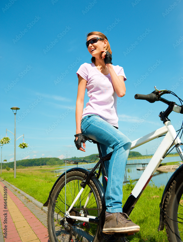 Young woman is sitting on her bicycle Young woman is sitting on her bicycle