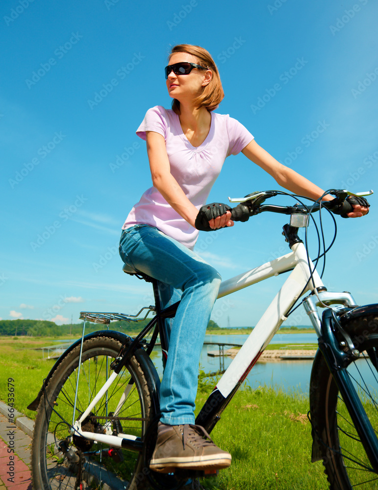 Young woman is sitting on her bicycle Young woman is sitting on her bicycle