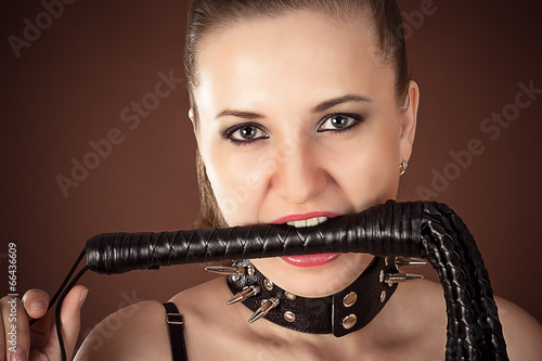 Portrait of mistress with a whip in the mouth photo
