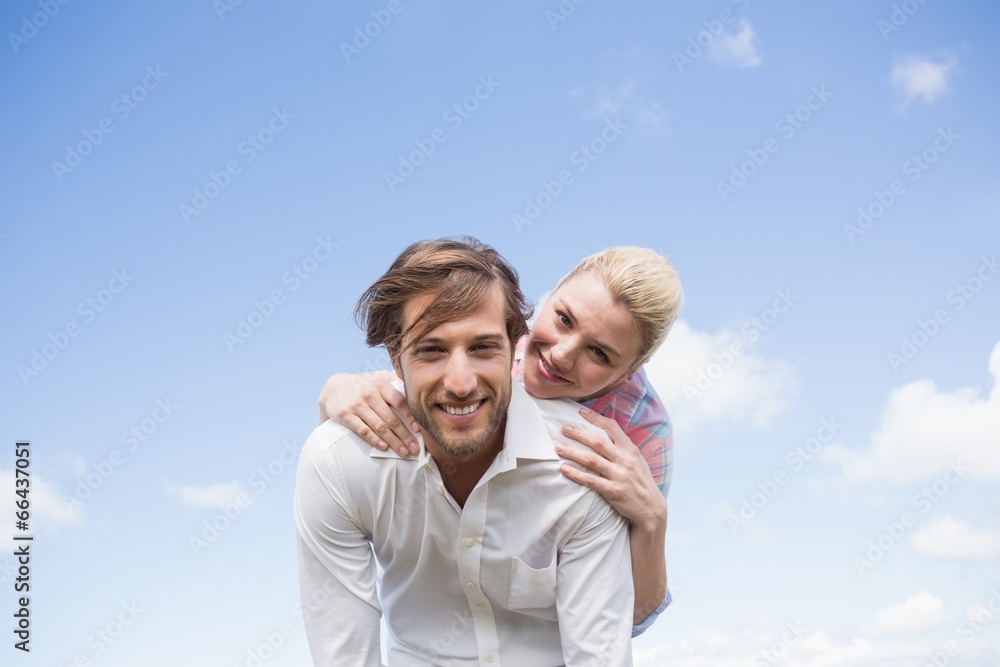 Handsome man giving piggy back to his girlfriend Handsome man giving piggy back to his girlfriend