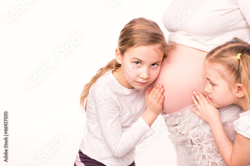 Happy children holding belly of pregnant woman