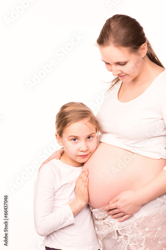 Happy child holding belly of pregnant woman