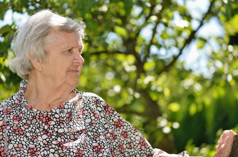 Senior woman smiling and dreaming in garden. Senior woman smiling and dreaming in garden.