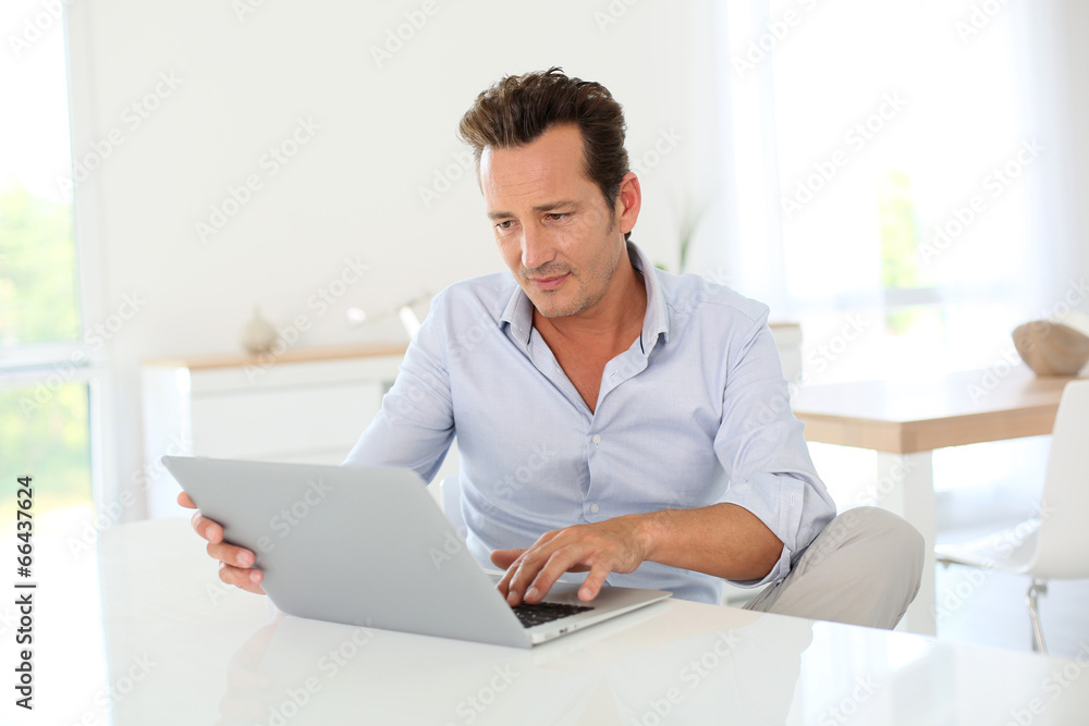 40-year-old man using laptop computer at home