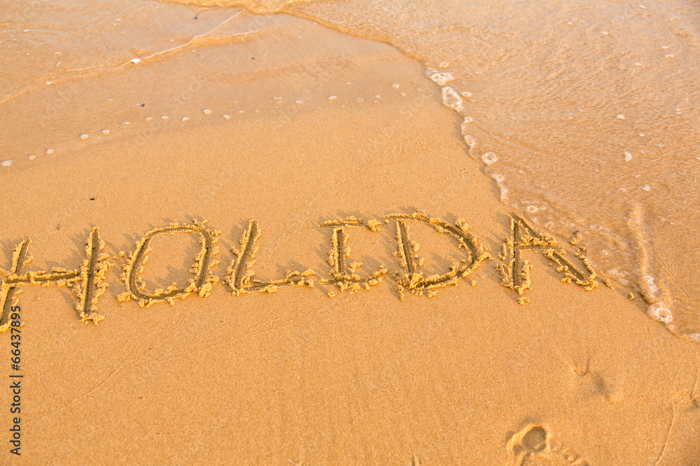 Fototapeta premium Word holiday on the yellow sandy beach