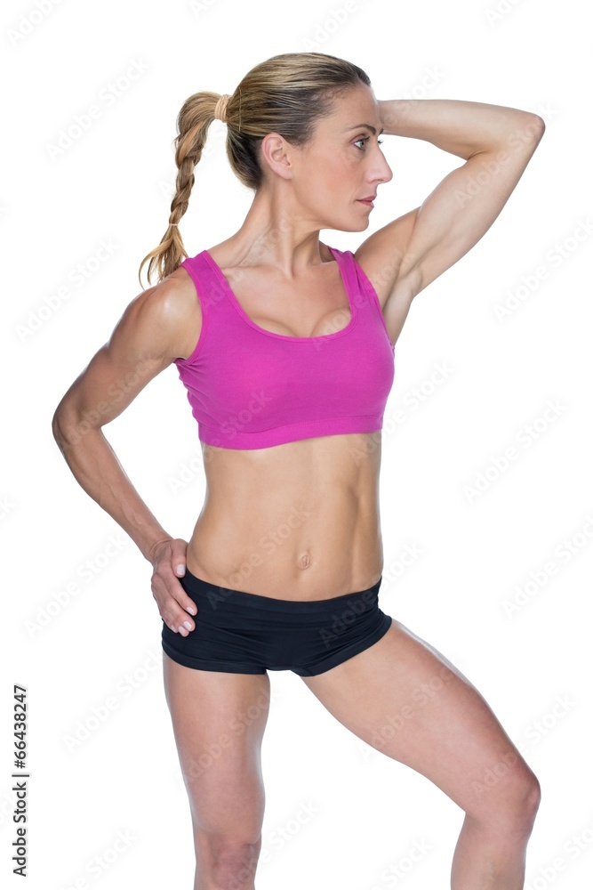 Female bodybuilder posing in pink sports bra Female bodybuilder posing in pink sports bra