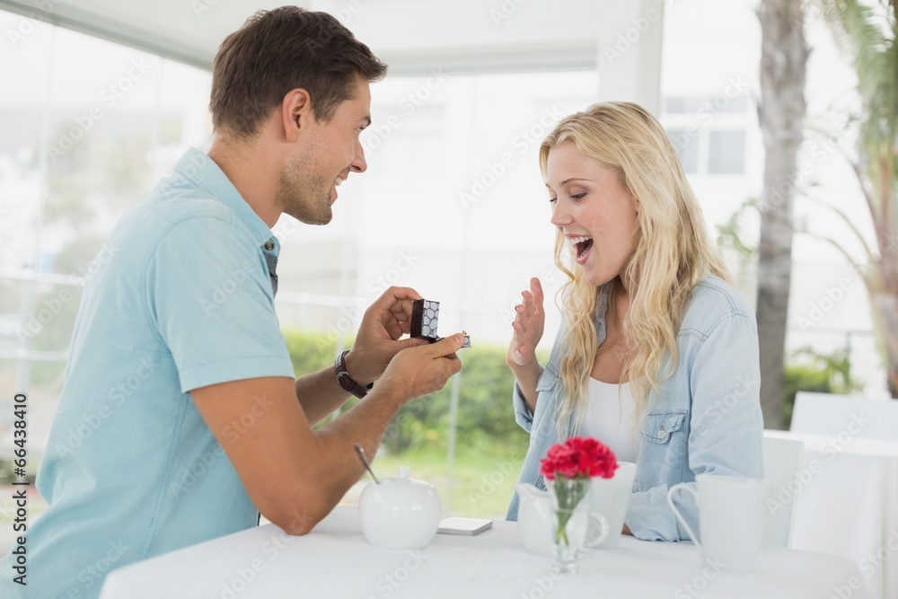Man proposing marriage to his shocked blonde girlfriend Man proposing marriage to his shocked blonde girlfriend