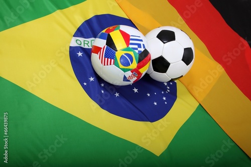 Fussb  lle mit Flaggen auf Flagge von Brasilien und Deutschland