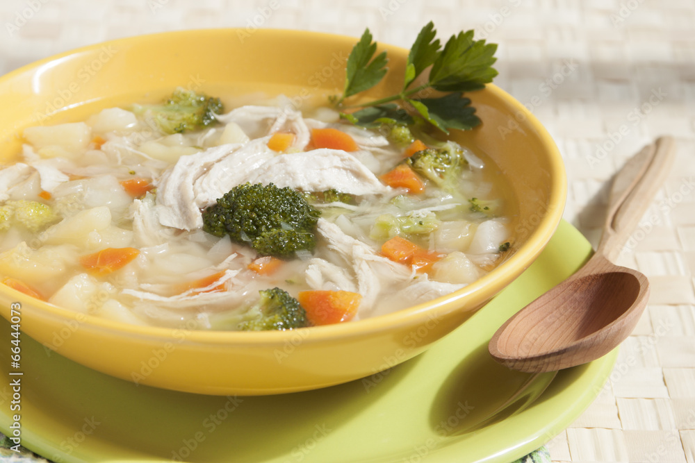 Broccoli soup with chicken, carrots, potatoes and parsley in yel Broccoli soup with chicken, carrots, potatoes and parsley in yel