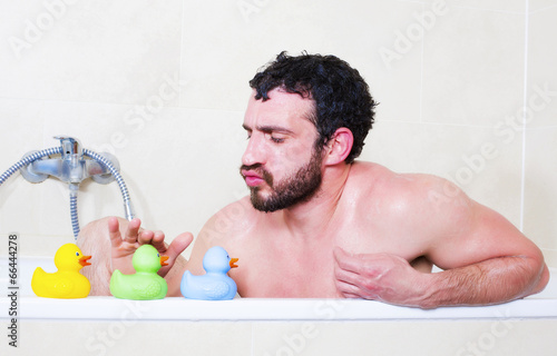 Fotografie man in bathtub with rubber duck