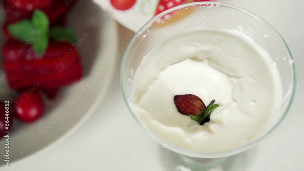 Strawberries falling into yoghurt dessert, super slow motion Strawberries falling into yoghurt dessert, super slow motion