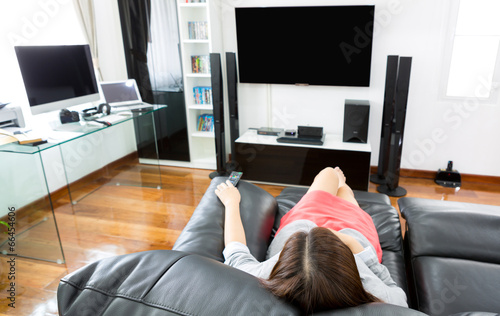 Bilde på lerret Business young woman watching TV in modern home office with comp