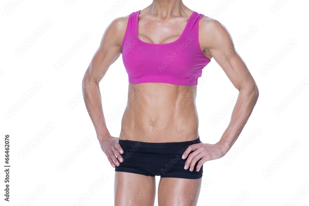 Female bodybuilder posing in pink sports bra and shorts mid sect Female bodybuilder posing in pink sports bra and shorts mid sect