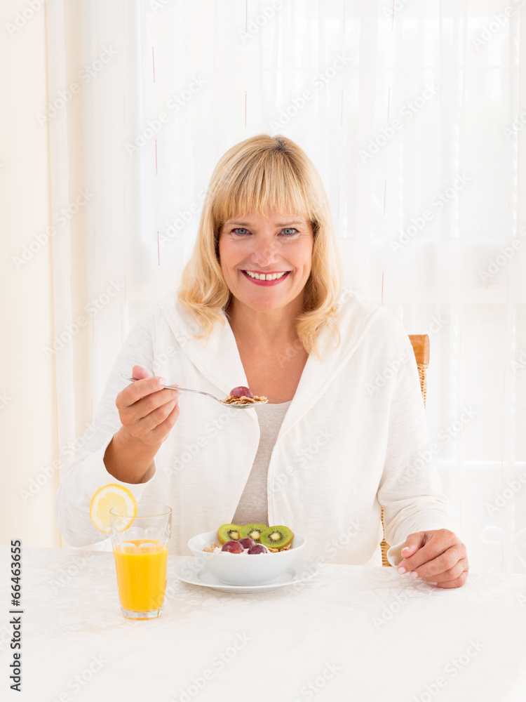 Beautiful mature woman enjoying a healthy cereals breakfast Beautiful mature woman enjoying a healthy cereals breakfast