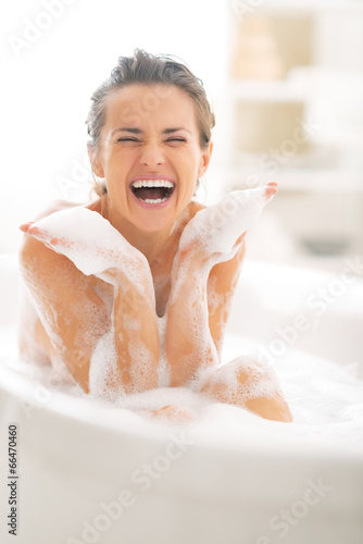Принти на полотні Happy young woman playing with foam in bathtub
