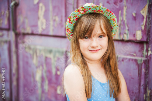 Outdoor portrait of a cute little girl in a hat