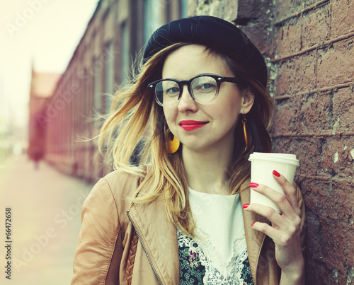Stylish woman in the street drinking morning coffee