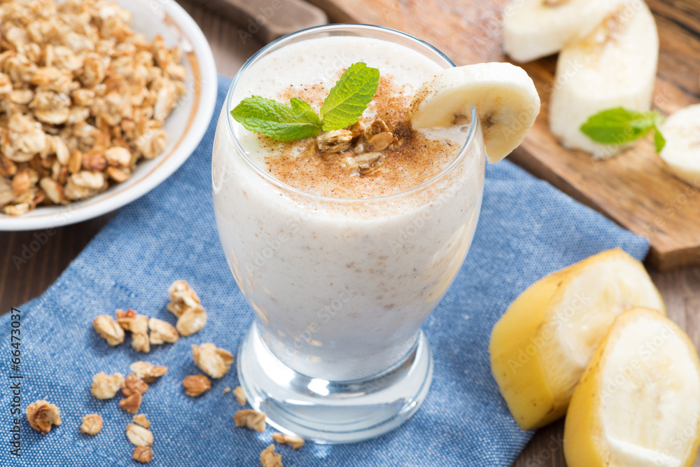 milkshake with banana, granola and cinnamon in a glass, top view milkshake with banana, granola and cinnamon in a glass, top view