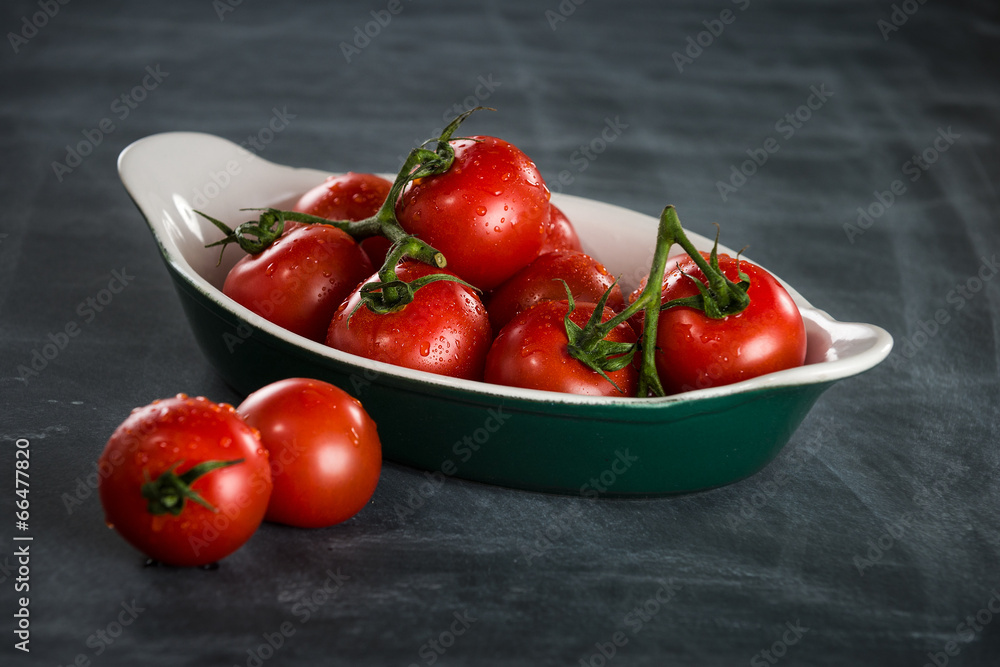 Ripe cherry tomatoes in a bowl on a black background Ripe cherry tomatoes in a bowl on a black background