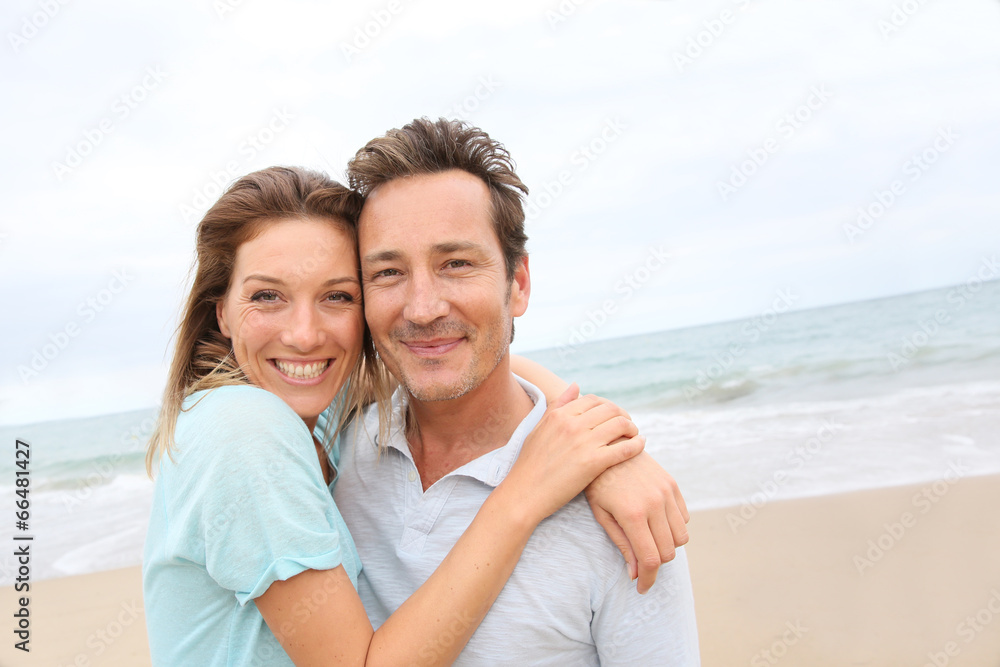 Happy 40-year-old couple enjoying day at the beach