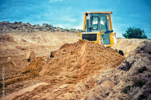 industrial bulldozer and excavator working with earth in sandpit