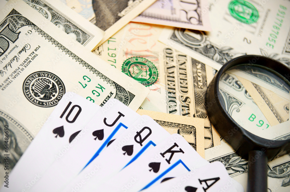 Game cards and magnifier on dollars. Game cards and magnifier on dollars.