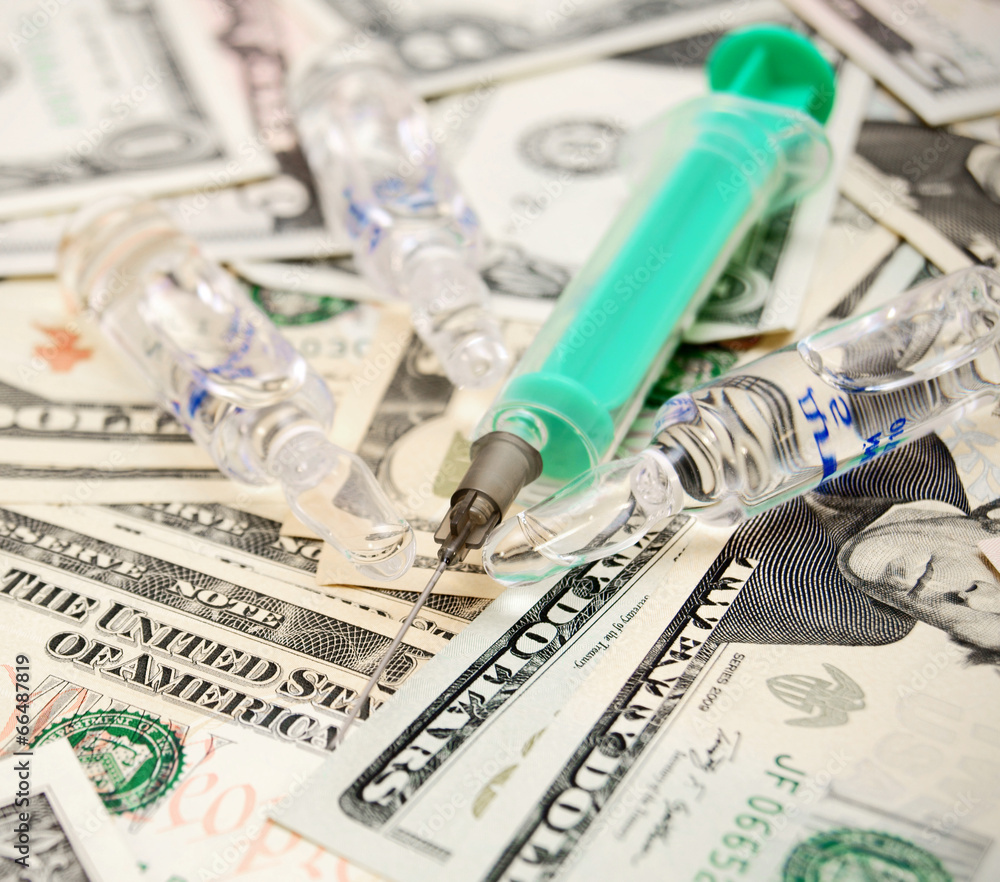 Syringe and ampoules on dollars. Syringe and ampoules on dollars.