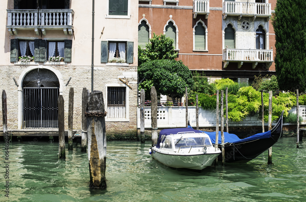 Ancient buildings and boats in the channel in Venice