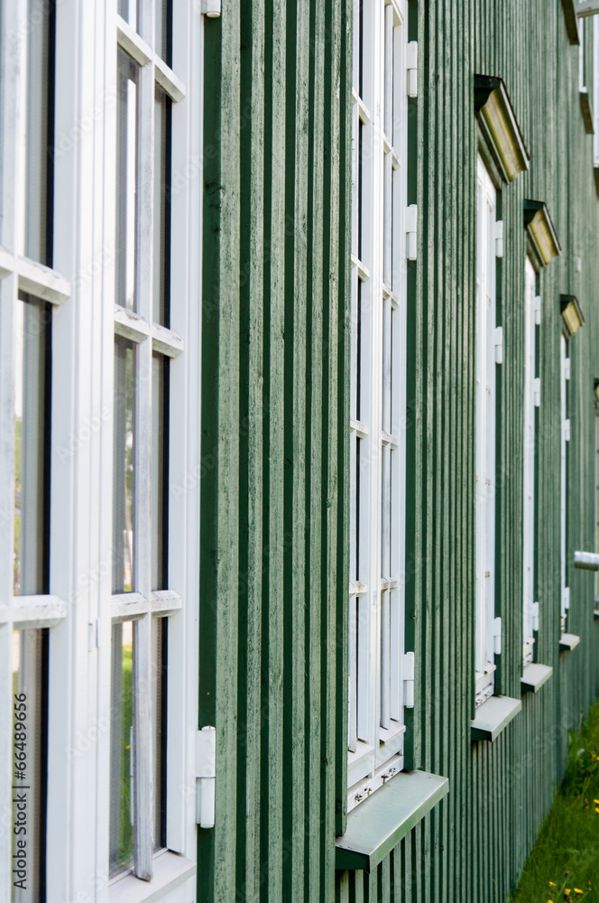 Obraz premium White wooden windows and green walls in Norway