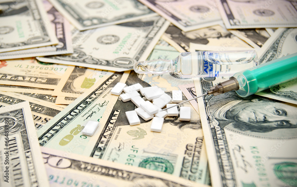 Tablets, a syringe on dollars. Tablets, a syringe on dollars.