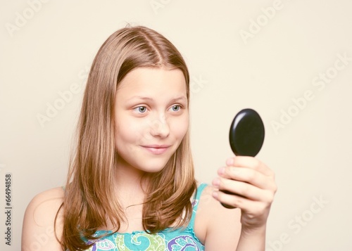 Teen girl looking at the mirror