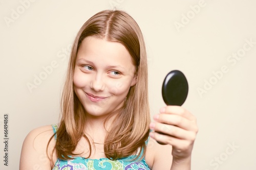Teen girl looking at the mirror