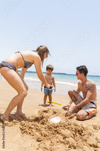Happy family playing on the beach