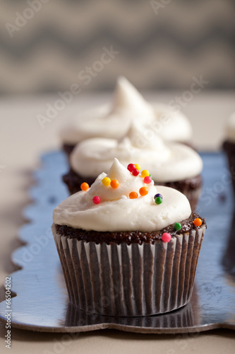 Chocolate gourmet cupcakes with sprinkles and buttercream frosting