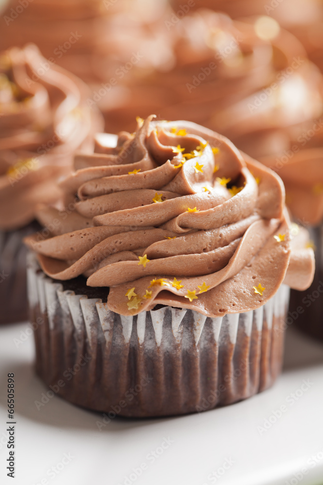 Pot of Gold cupcakes vertical shot - chocolate cake with a rich salted  caramel center topped with chocolate buttercream and edible gold stars  Stock Photo
