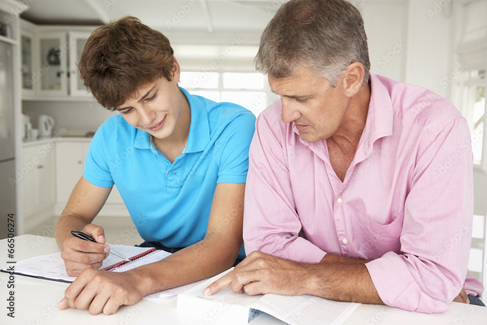 Father helping teenage son with homework Father helping teenage son with homework