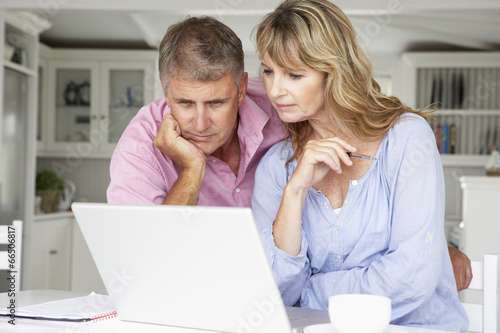 Fotografía Mid age couple working at home on laptop