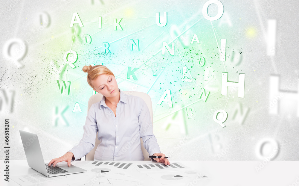 Business woman at desk with green word cloud