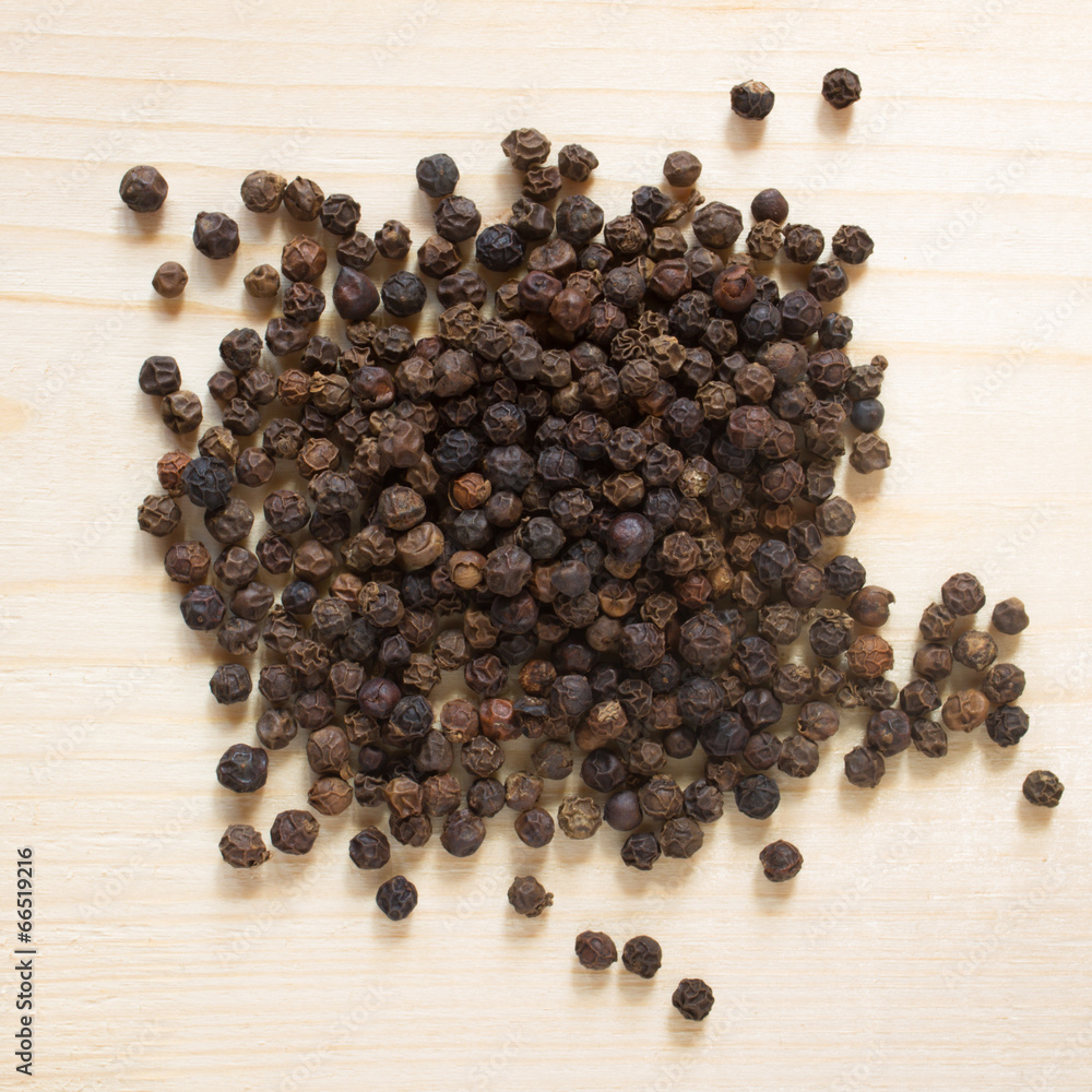 black pepper on wooden background - top view black pepper on wooden background - top view
