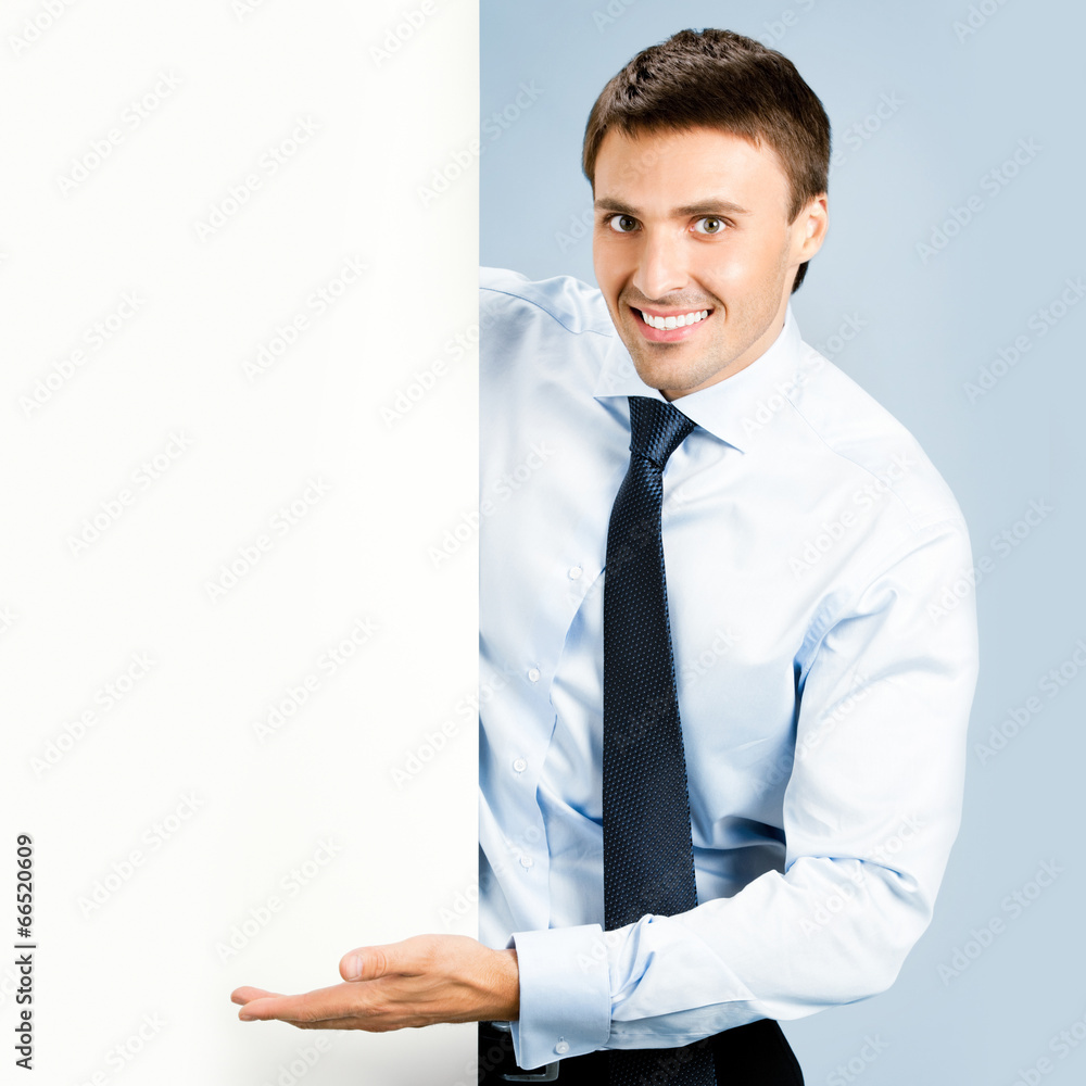 Business man showing blank signboard, over blue Business man showing blank signboard, over blue