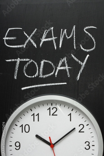 Exams Today written on a blackboard above a clock