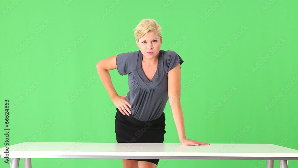 Seductive businesswoman standing by desk Seductive businesswoman standing by desk