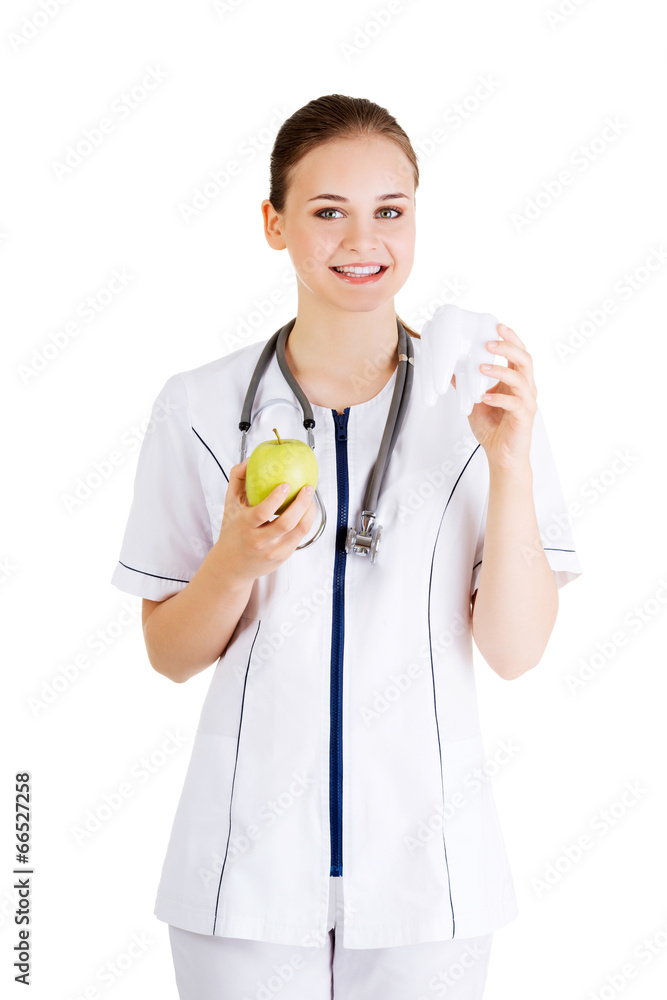 Female dentist with green apple and big tooth Female dentist with green apple and big tooth