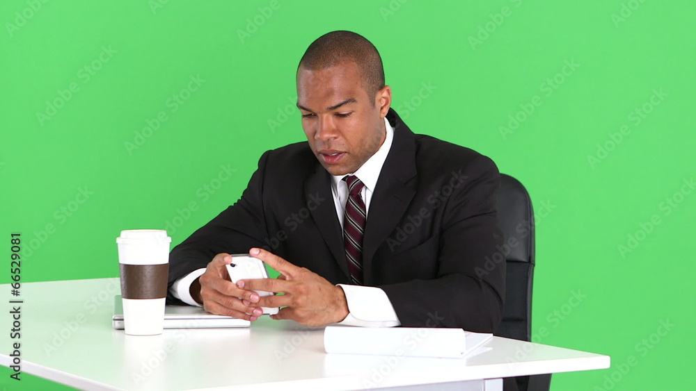 Male executive at desk with cell phone Male executive at desk with cell phone