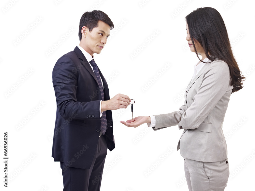 angry man handing car key to unhappy woman