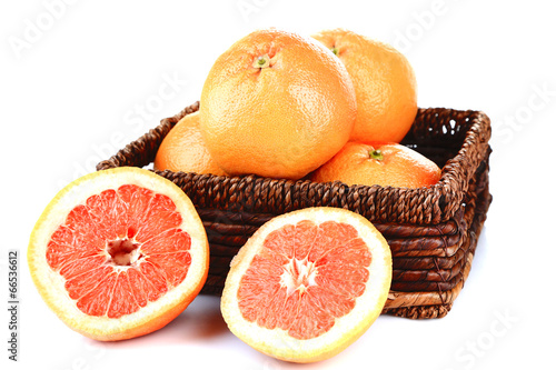 Ripe grapefruits in wicker basket isolated on white