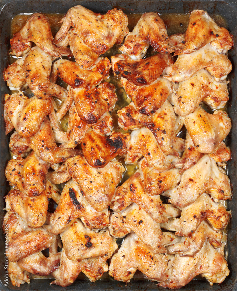many roasted spicy chicken wings on hot tray