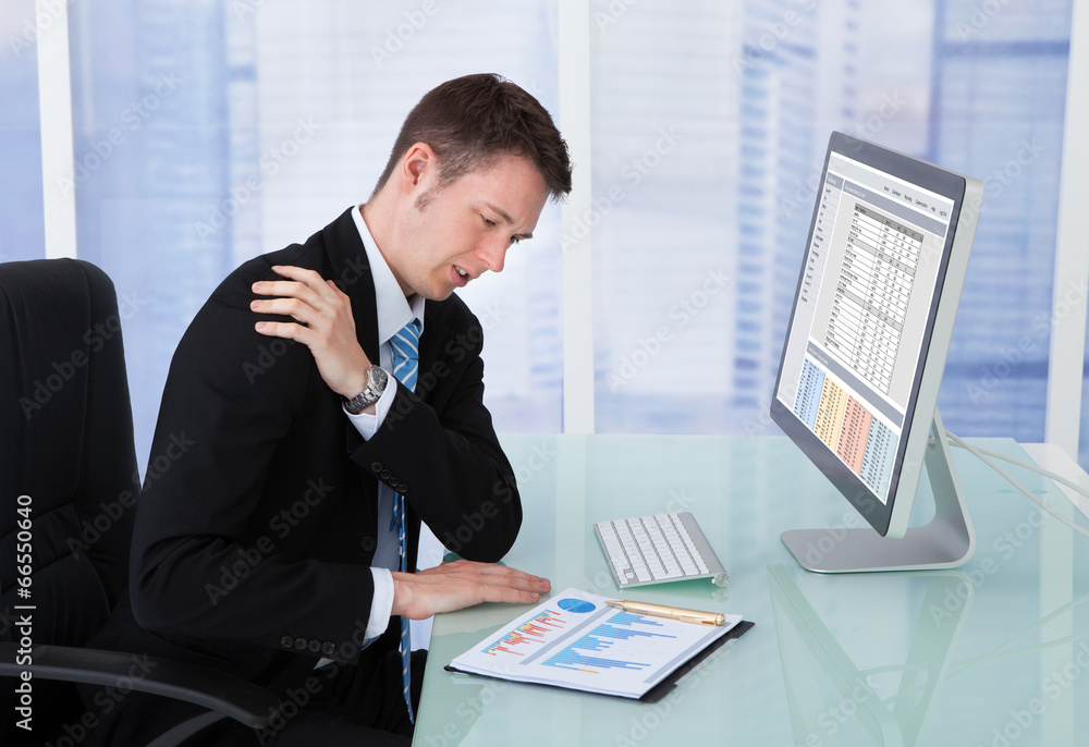 Businessman Having Shoulder Pain At Computer Desk Businessman Having Shoulder Pain At Computer Desk